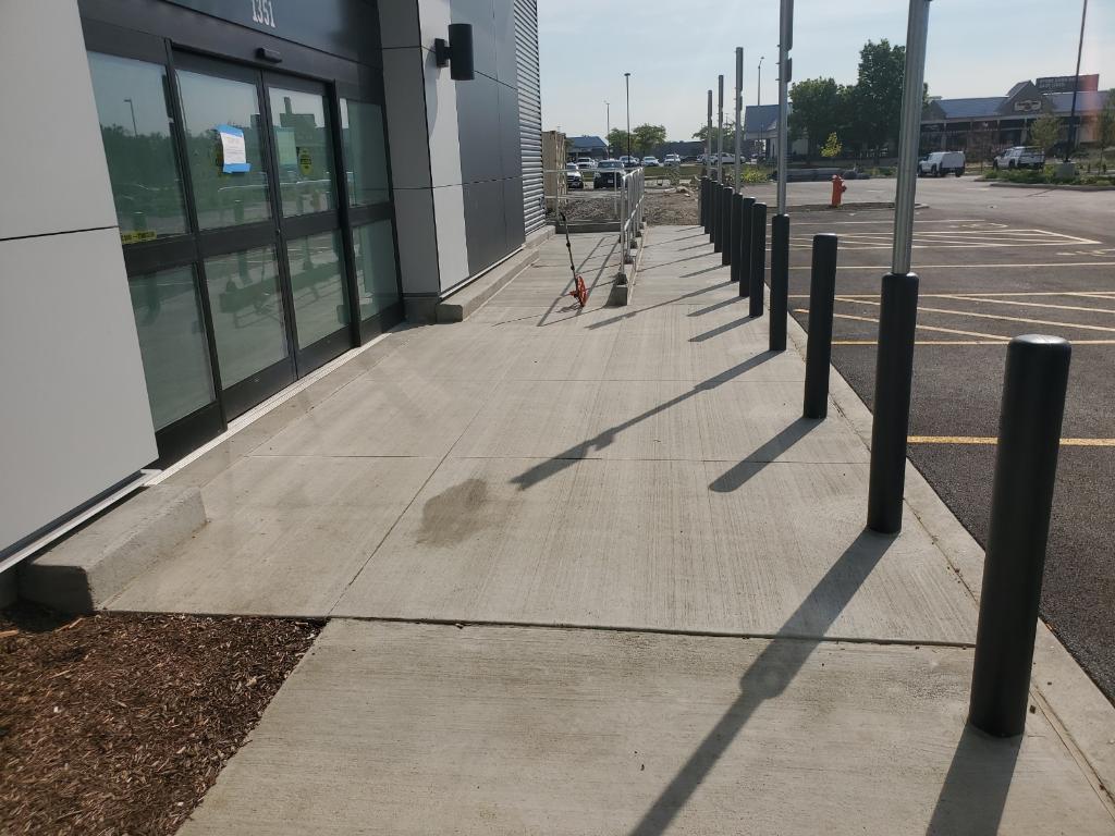 Finished commercial storefront entry sidewalk with bollards